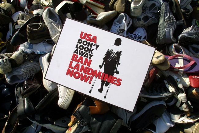 Minų uždraudimo ženklas yra ant piramidės, sukrautos batų, surinktų per pastaruosius kelis mėnesius per JAV kampaniją prieš minų uždraudimą.