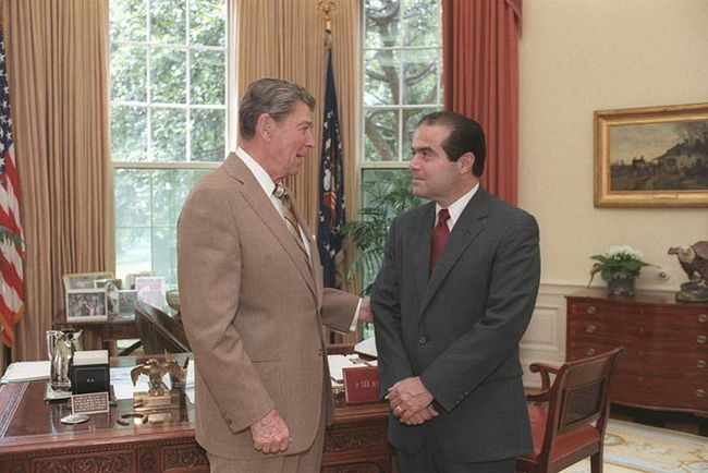 Prezidentas Ronaldas Reiganas ovaliame kabinete kalbasi su kandidatu į Aukščiausiojo Teismo teisėją Antoninu Scalia, 1986 m.