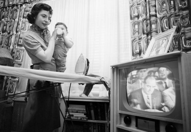 Nuotrauka, kurioje moteris stebi senatorių Josephą McCarthy per televizorių