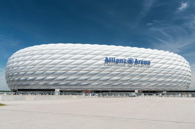 išlenkto sporto stadiono vaizdas iš šono, išpūstas išpūstų ETFE plastikinių plokščių išorinis vaizdas, iš šono atrodantis kaip balta protezuota padanga.