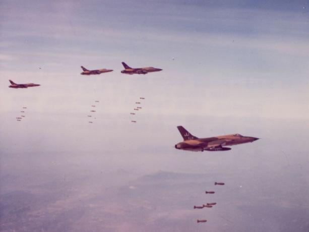 Keturios „F-105“ žalios ir rudos kamufliažinės bombos bombarduoja šiaurės Vietnamą.