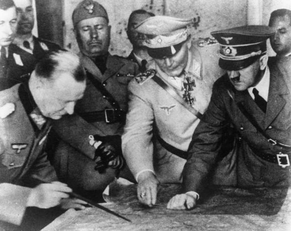 Adolfas Hitleris (1889 - 1945), Hermann Goering (1893 - 1946) ir kiti planuoja karinę strategiją Vokietijos armijos štabe. Fone - italų diktatorius Benito Mussolini, apie 1940 m.