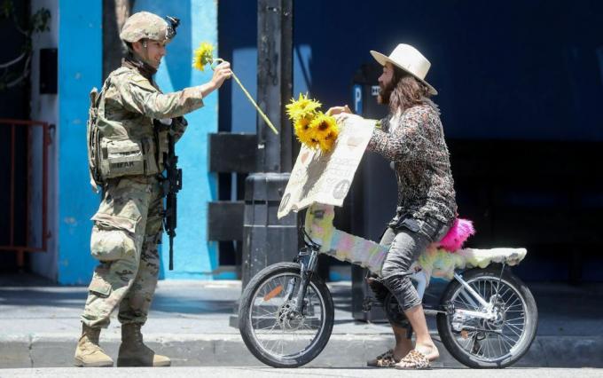 Nacionalinės gvardijos karys gauna protestuotojo gėlę per taikią demonstraciją dėl George'o Floydo mirties Holivude 2020 m. Birželio 3 d.