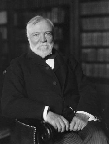 Vintažinė Amerikos istorijos nuotrauka, kurioje Andrew Carnegie sėdėjo bibliotekoje.