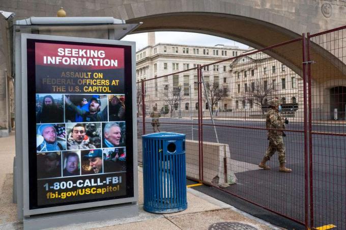 Nacionalinis gvardietis eina pro plakatą, ieškodamas informacijos apie JAV Kapitolio išpuolį 2021 m. Sausio 19 d.